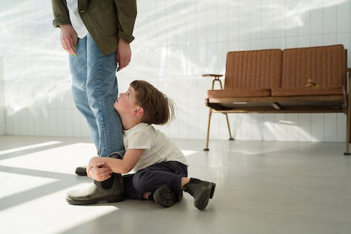 A child clinging to an adult’s leg