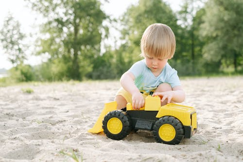 a child playing with a toy car in the sand
