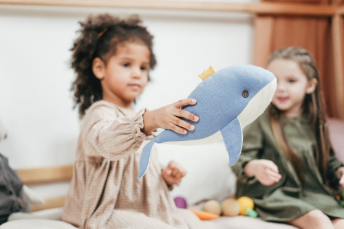 Little girl playing with a whale toy