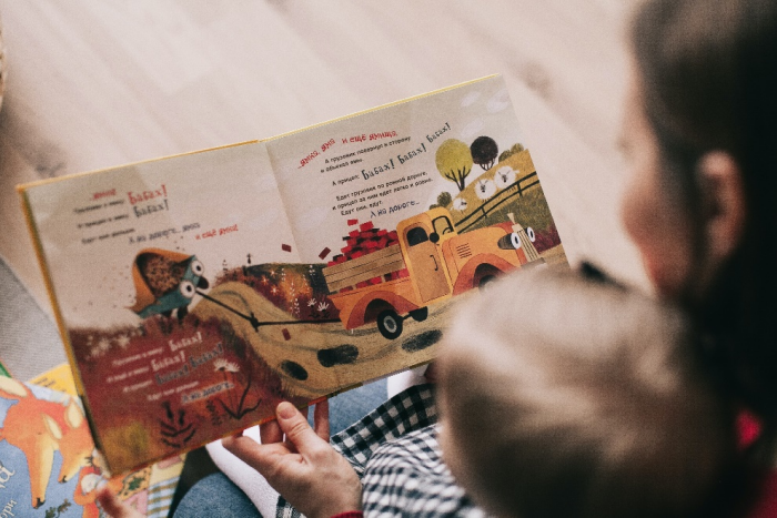Caregiver reading a book to a toddler