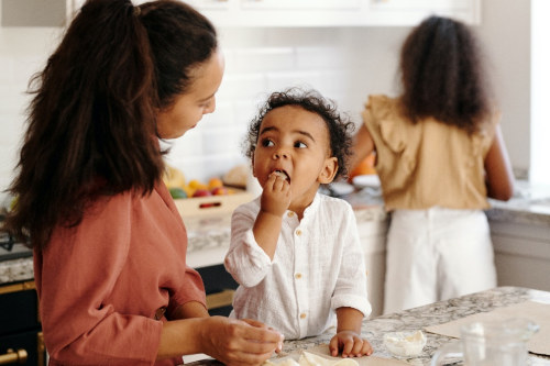 toddler looking at his mother while eating