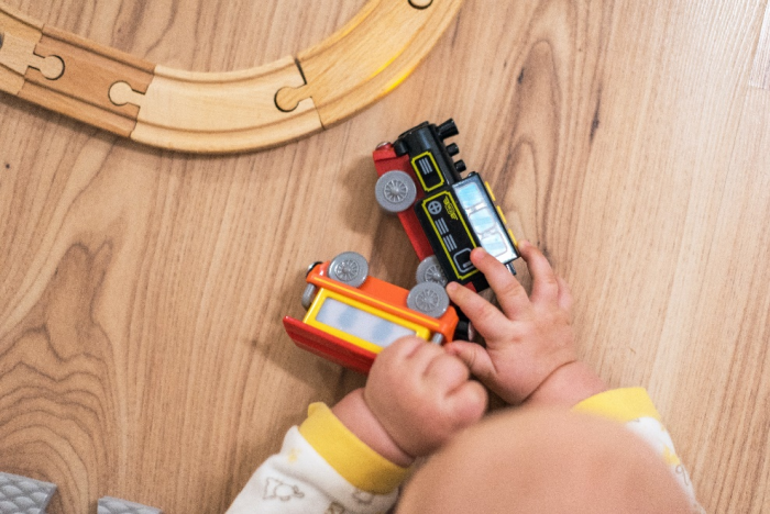 Baby holding toy trains