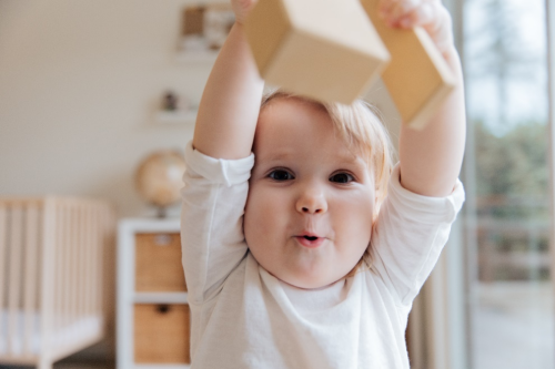 Toddler playing with wooden block